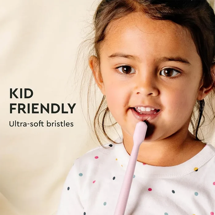 Child using a pink toothbrush with text 'KID FRIENDLY Ultra-soft bristles' on a beige background