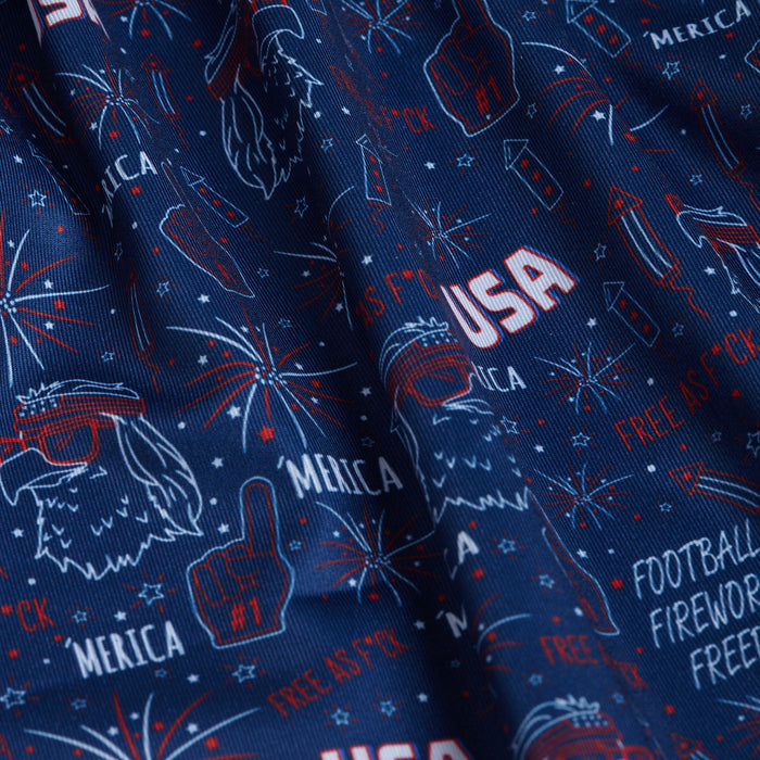 The 'Merica - Navy - Polo features a lively red, white, and blue patriotic print with fireworks, a foam finger, and an eagle in sunglasses. Its moisture-wicking fabric and athletic fit ensure all-day comfort.
