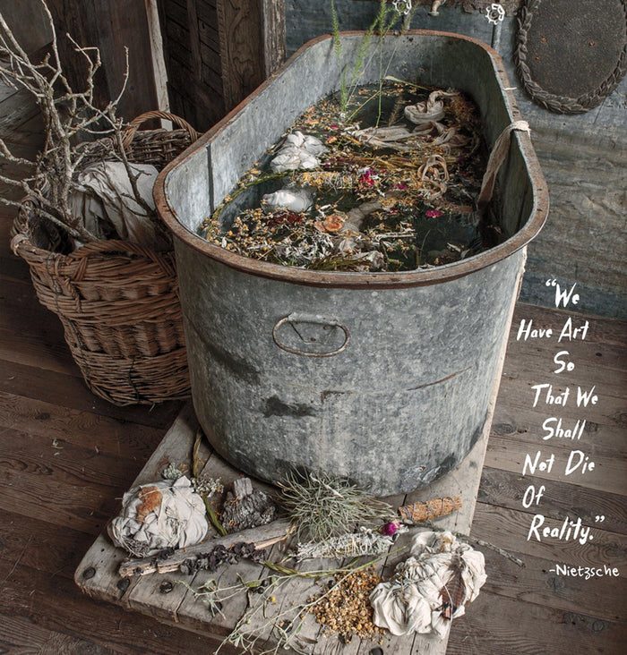 Vintage metal tub with artisan fabric bundles, dried flowers, and rustic decor in a whimsical Magnolia Pearl setting