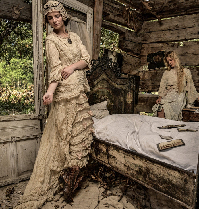 Two women in Magnolia Pearl artisan vintage dresses and whimsical lace in rustic, antique bedroom