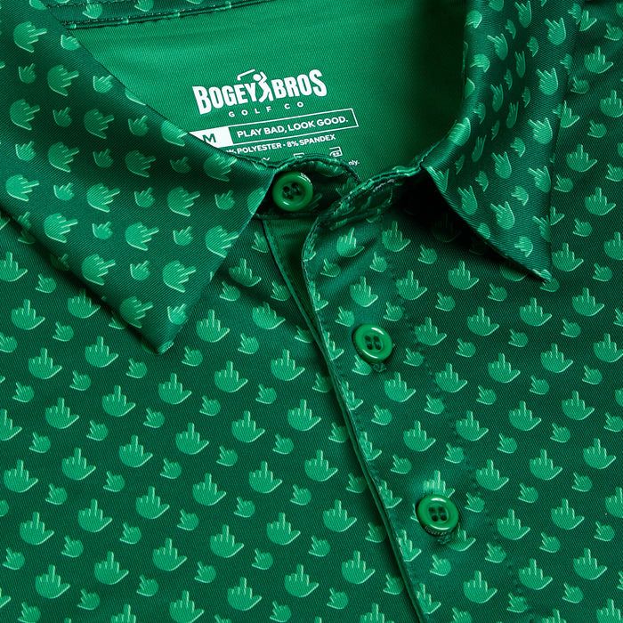 Close-up of Birdie Finger - Irish Goodbye - Polo: a green athletic-fit shirt with light green hand icons showing a raised middle finger, green buttons, and BOGEY BROS. label featuring the tagline "Play bad, look good.