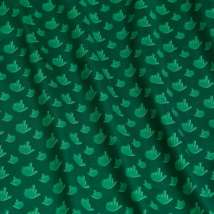 The Birdie Finger - Irish Goodbye - Polo features green fabric with a repeating pattern of stylized hand shapes giving the middle finger. It offers UPF 50 protection and a subtle sheen, combining playful style with functional sun safety.