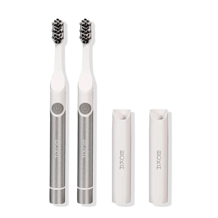 Two Boka Pocket Electric Toothbrushes with Sonic Pulse Technology and white caps on white.