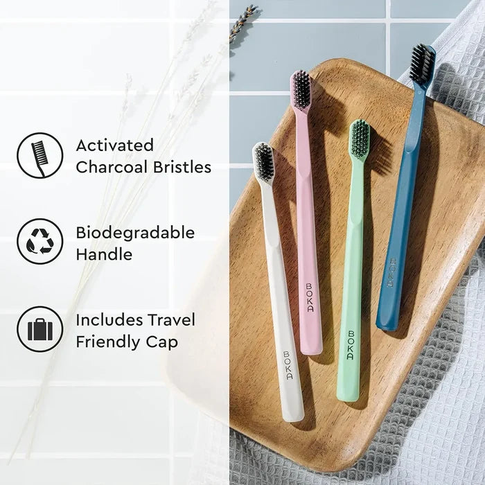 Set of four toothbrushes in different colors on a wooden tray with text highlighting features.