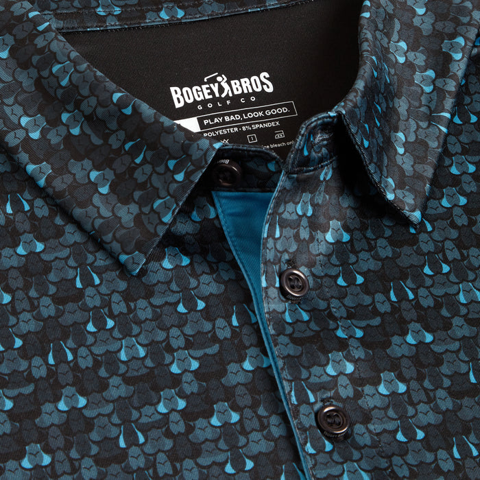 Close-up of the Eyes Up Here - Zapped - Polo: a buttoned shirt with blue and teal scale pattern on black. Made with moisture-wicking, athletic fit fabric (92% polyester, 8% spandex), it keeps you cool—PLAY BAD. LOOK GOOD.