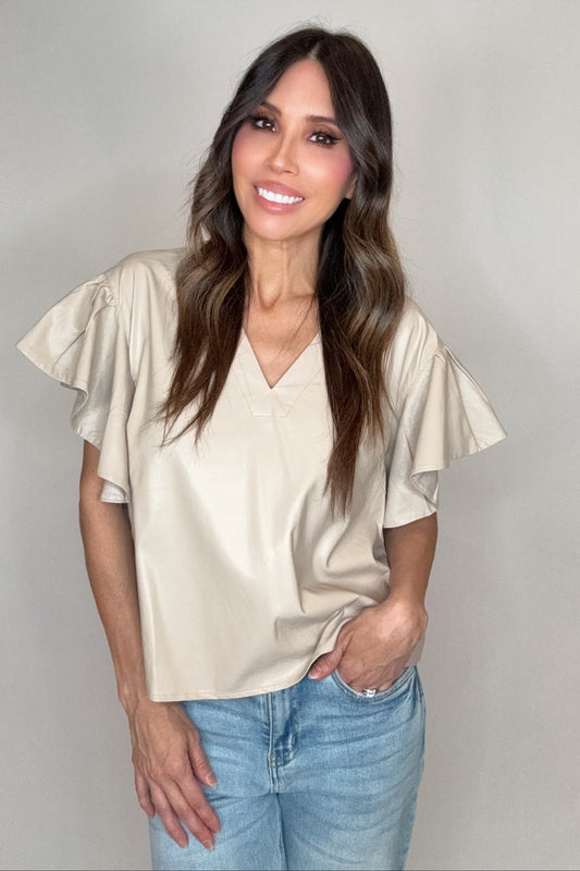 Solid neutral faux leather v-neck top with dramatic ruffle short sleeves and a polished boutique silhouette.