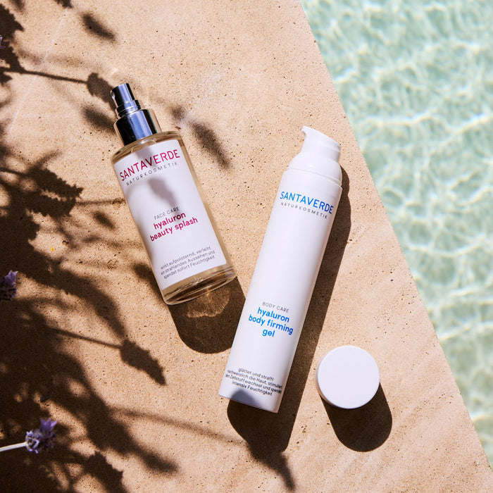 Santaverde hyaluron beauty splash und hyaluron body firming gel auf Stein neben dem Pool