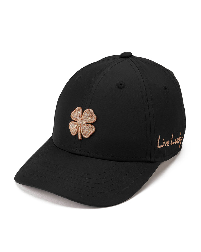 A black baseball cap featuring a glittery rose gold embroidered shamrock on the front and 'Live Lucky' script embroidery on the side, shown against a plain white background.