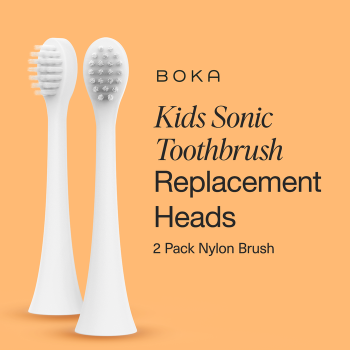 Two white Replacement Heads for Kids Sonic Toothbrush with soft bristles on an orange background.