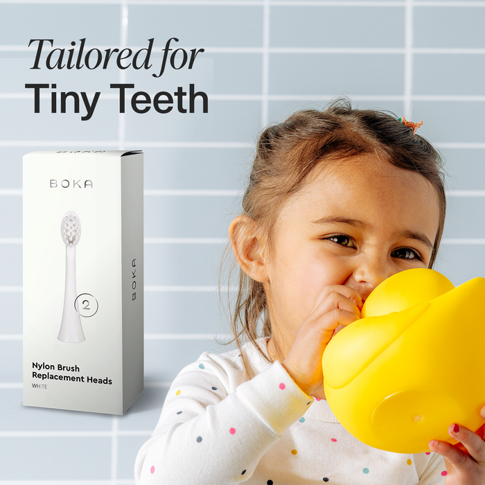Young child holding a yellow duck, with Replacement Heads for Kids Sonic Toothbrush.