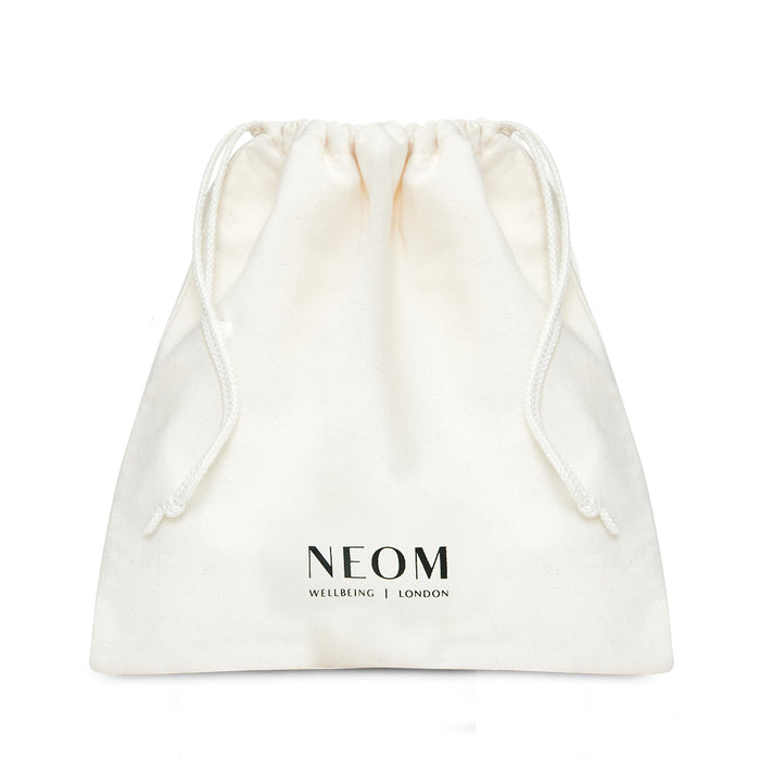 White drawstring bag with NEOM branding on a white background