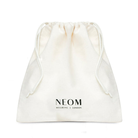 White drawstring bag with NEOM branding on a white background