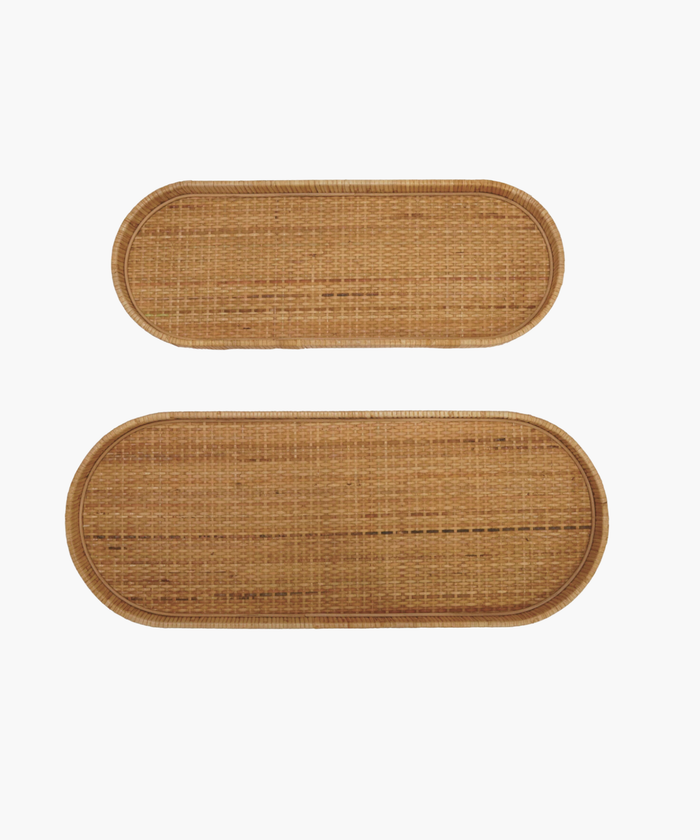 Two oval wicker handwoven trays with rounded edges, one smaller above the larger one, against a white background. Natural, rustic texture. | SW Home