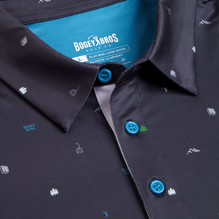Close-up of a dark, athletic fit Pine - Polo featuring small white golf-themed icons, blue buttons, blue inner collar, and Bogey Bros label. Made with moisture wicking fabric for comfort on and off the course.