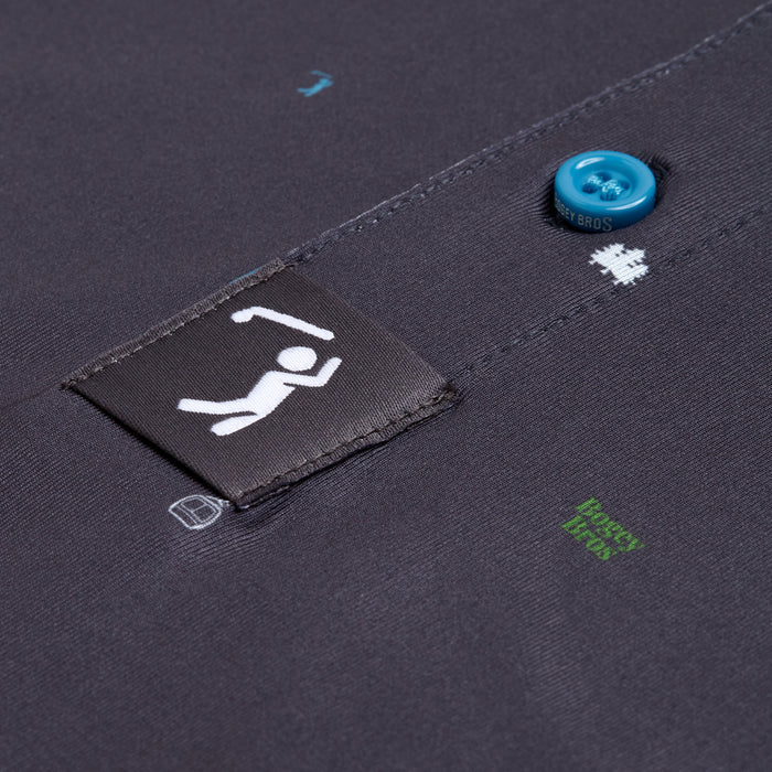 Close-up of the Pine - Polo: a dark grey athletic-fit shirt with blue button, small white graphics, black label showing a white stick figure raising its arms, and tiny green and blue text near the button and label.
