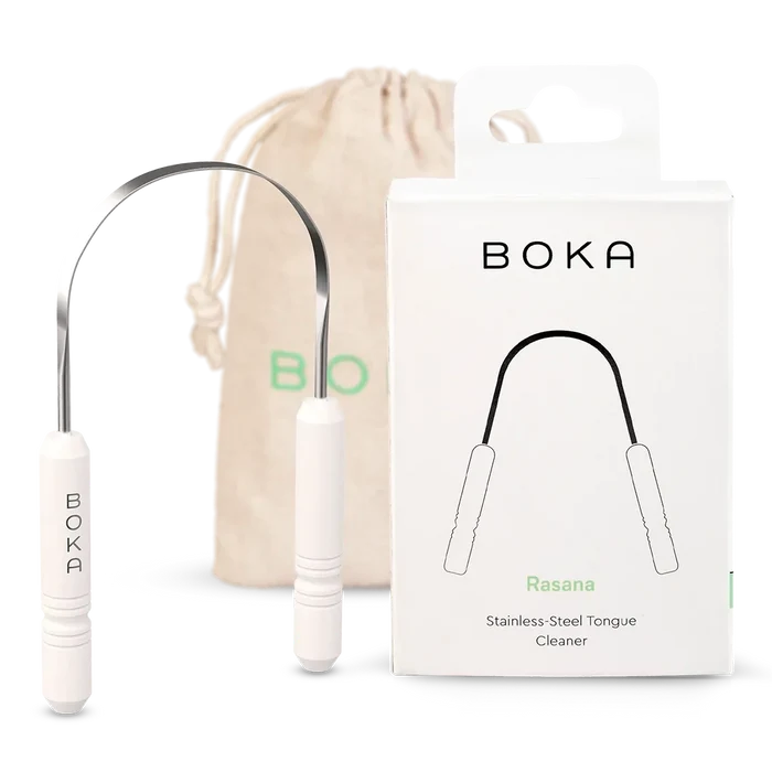 Boka stainless steel tongue cleaner with packaging and drawstring bag on a white background