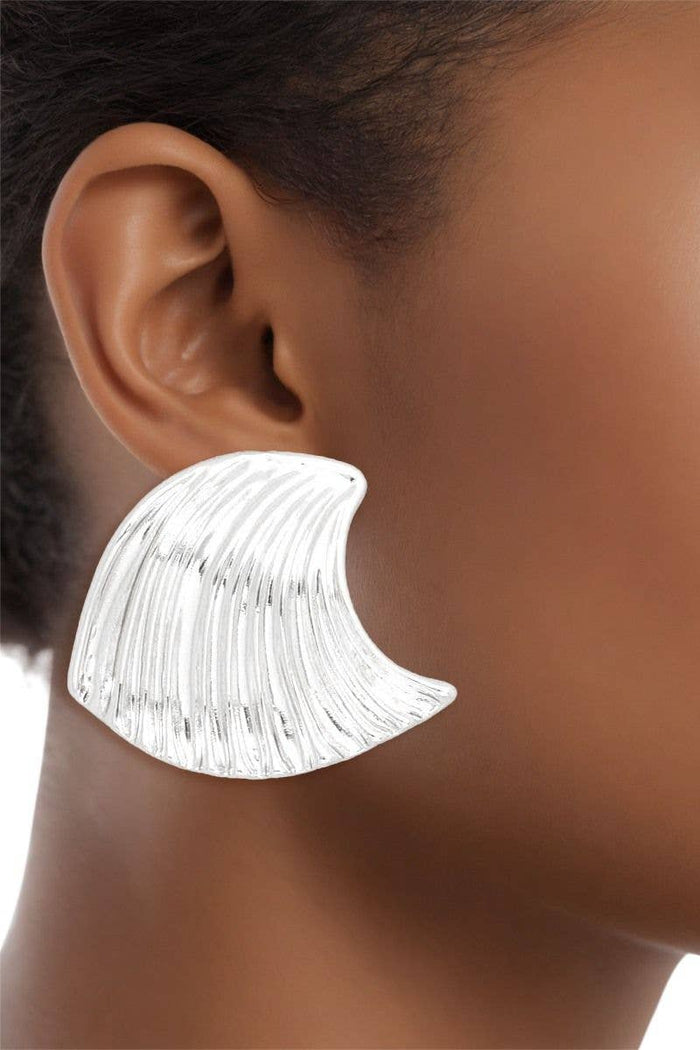 Polished silver acrylic stud earrings shaped like curved ocean waves with a sculptural statement silhouette.