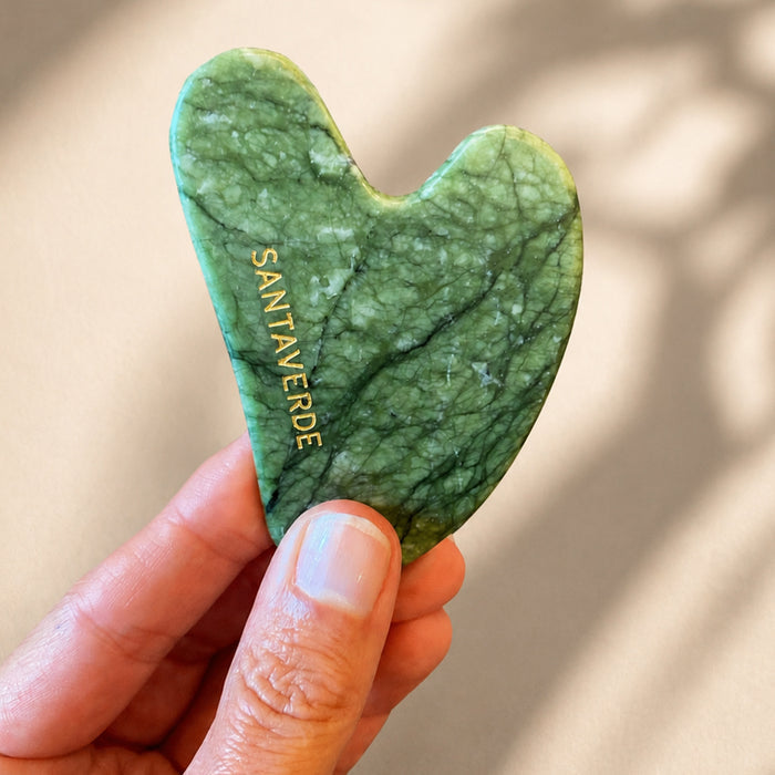 antaverde Gua Sha Stein aus grünem Naturstein wird in einer Hand gehalten