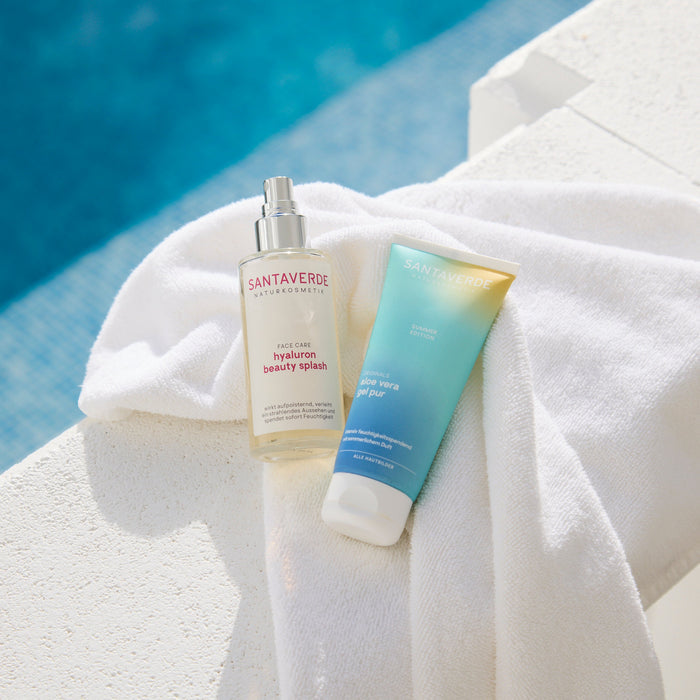 Santaverde hyaluron beauty splash und aloe vera gel pur mit Duft auf einem Handtuch neben dem Pool