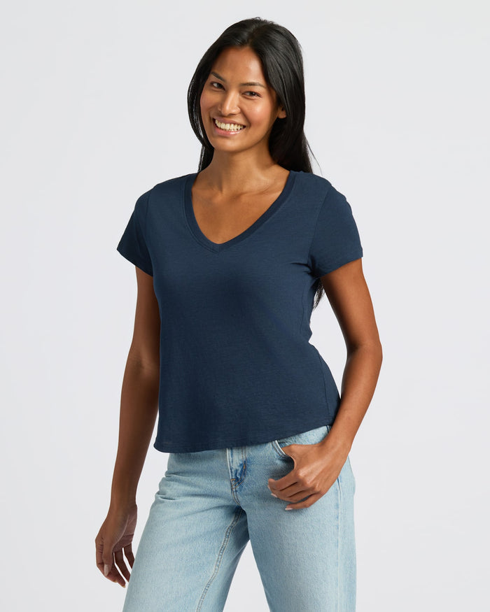 Woman wearing Womens Navy Relaxed Slub V-Neck Tee and jeans, smiling.